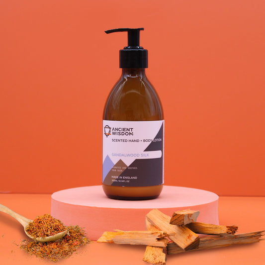 Hand- & Body Lotion Sandelholz und Seide – auf Podest mit Seidenblüten und Sandelholzstäbchen arrangiert