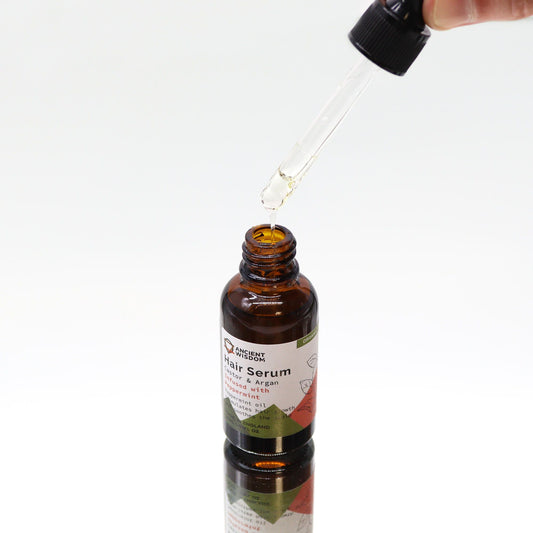 Haarserum Pfefferminze – Glasflasche mit Tropfer darüber gehalten