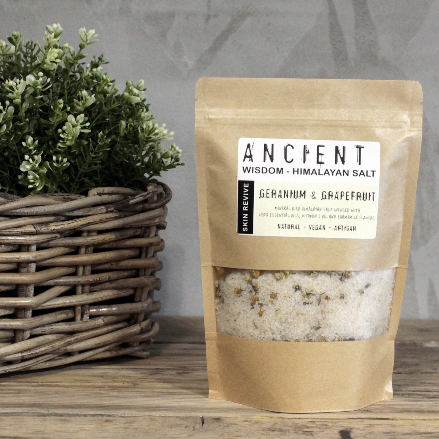 Himalaya Aromatherapie Badesalz Pflege und Wohlgefühl – auf Holztisch mit Grünpflanze arrangiert