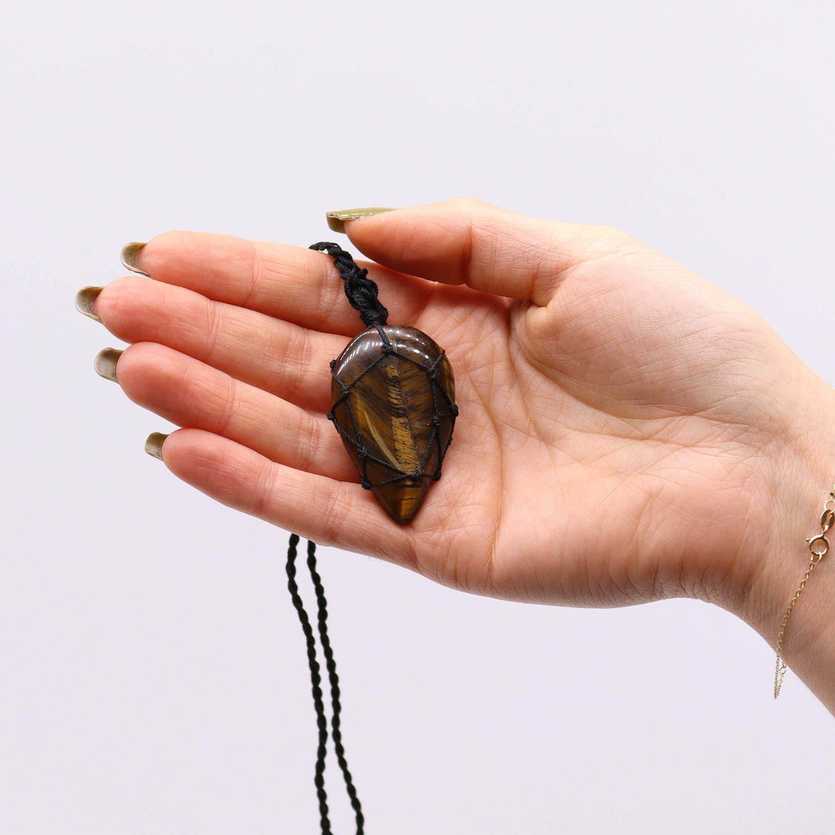 Halskette mit Tigerauge-Anhänger – in der Hand gehalten