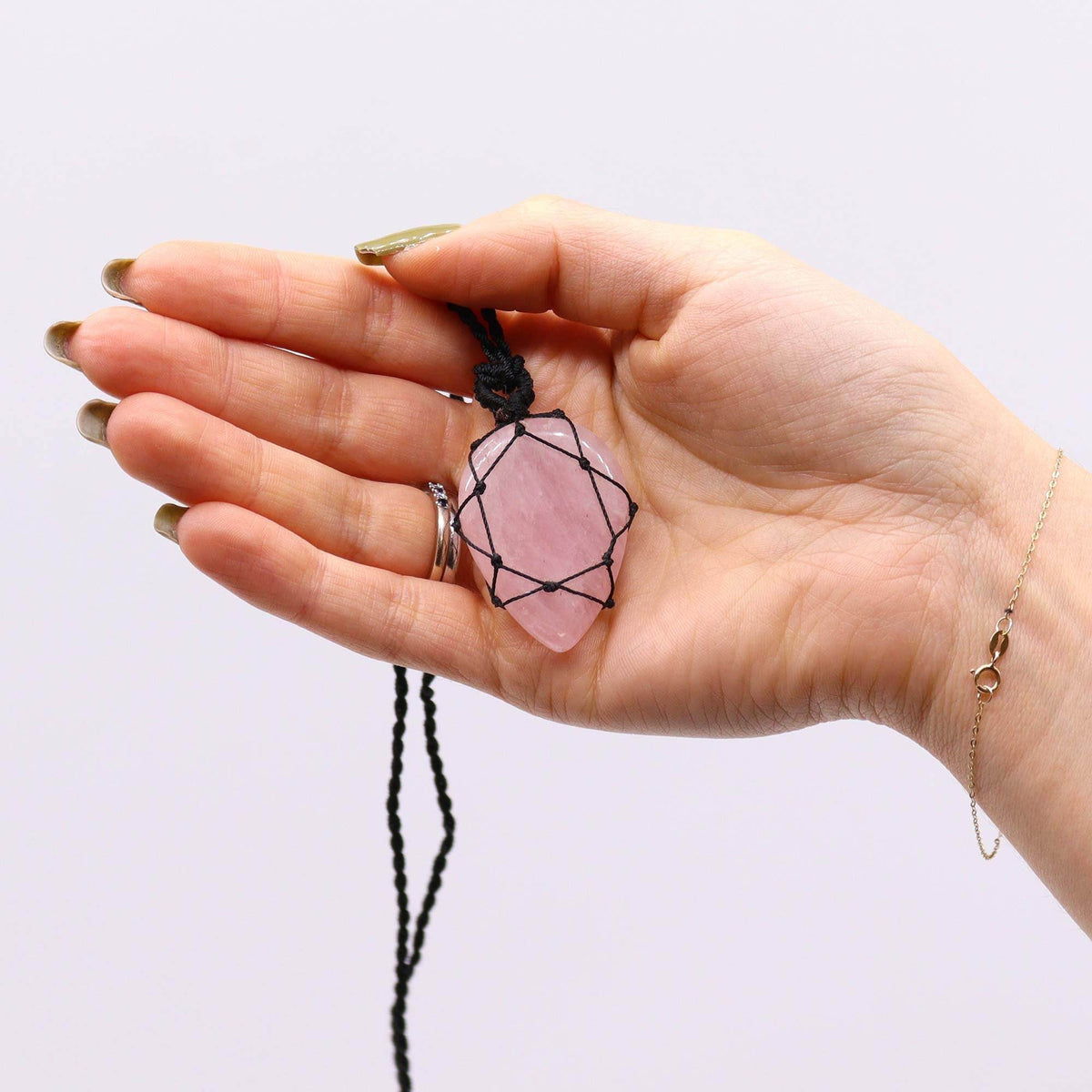 Halskette mit Rosenquarz-Anhänger – in der Hand gehalten