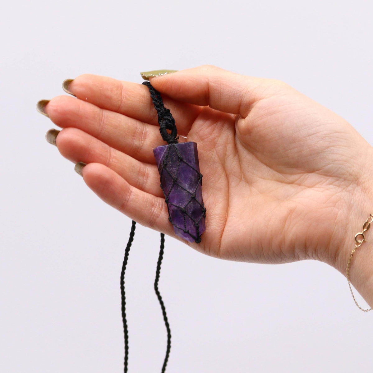 Halskette mit Amethyst-Anhänger – in der Hand gehalten