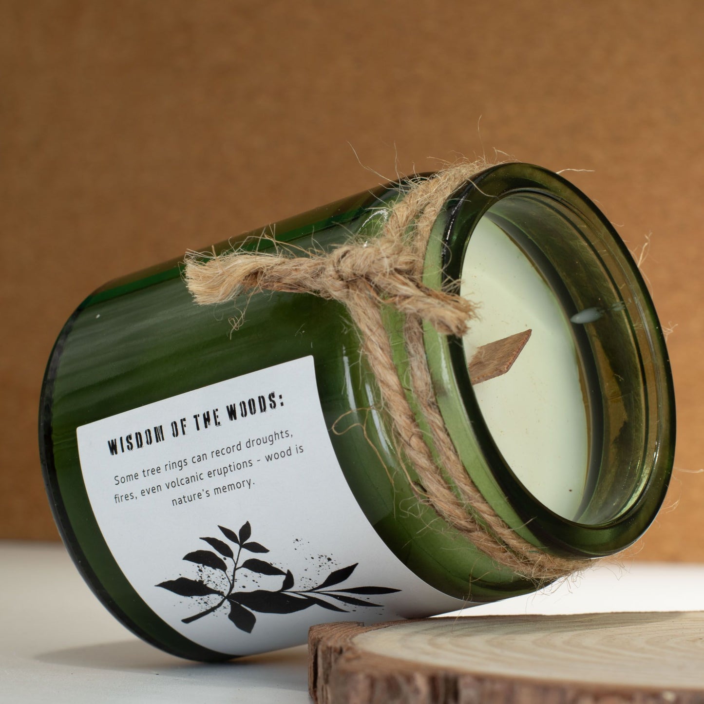 Greenman Woodwick Duftkerze Salbei und Minze – geöffneter Glasbehälter auf Baumscheibe, Holzdocht sichtbar