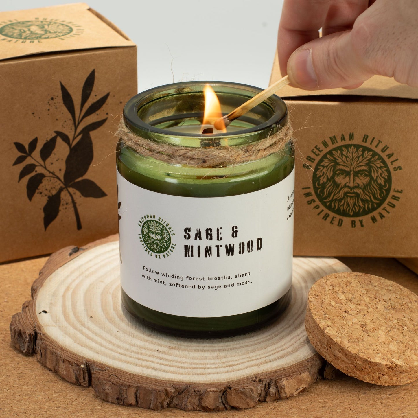 Greenman Woodwick Duftkerze Salbei und Minze – brennende Kerze auf Baumscheibe, mit Zündholz angezündet