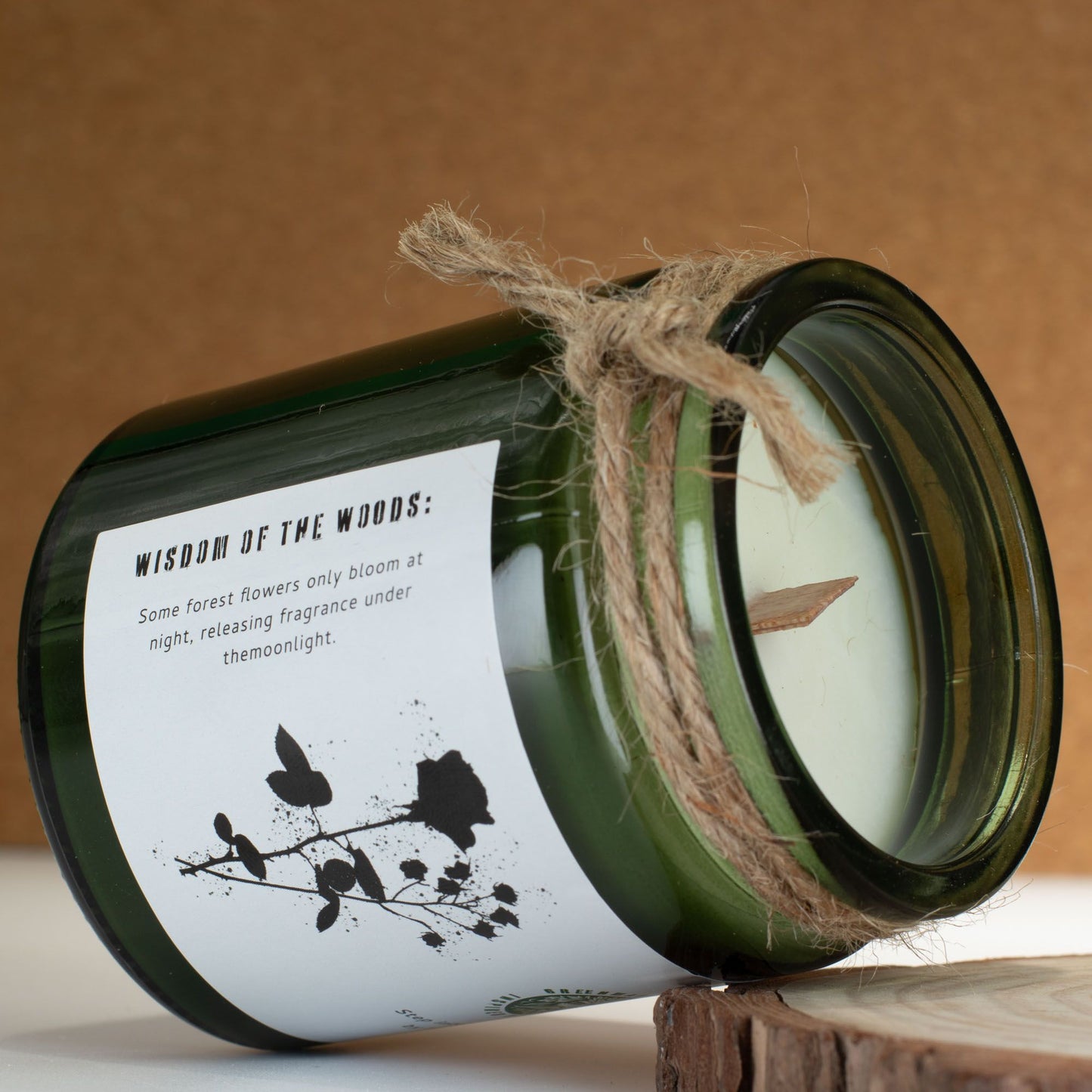 Greenman Woodwick Duftkerze Mitternachtsrose – geöffneter Glasbehälter auf Baumscheibe, Holzdocht sichtbar