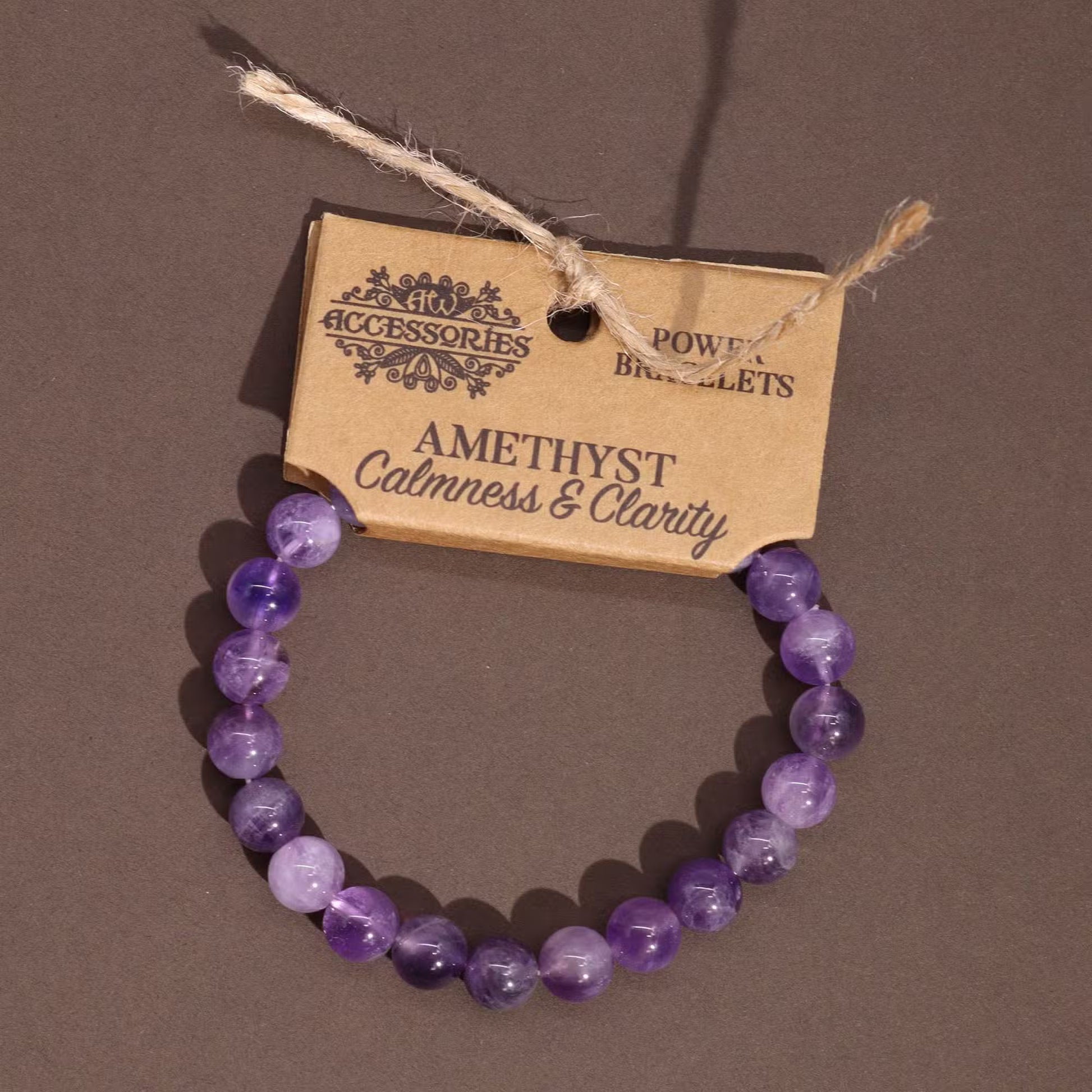 Edelstein-Kraftarmband Amethyst – auf braunem Untergrund